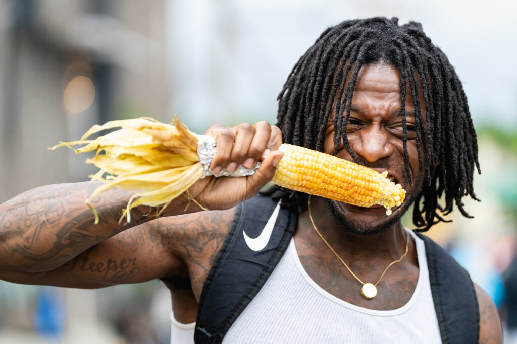 Man with locks eating corn